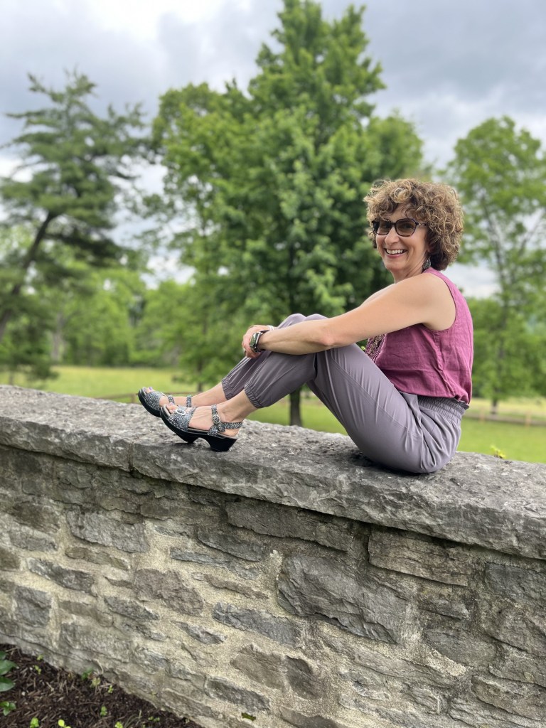 A picture of me sitting on a stone wall.